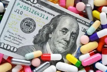 Trulicity lawsuit: Pills on money dollars - Medicine prescription drugs cost concept - healthcare insurance expenses