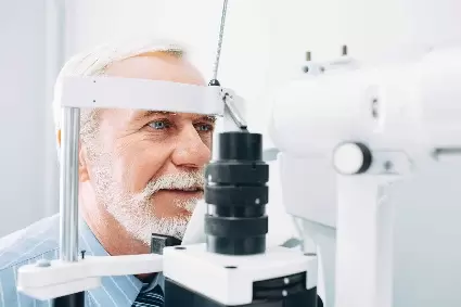 older man with white beard getting eye exam
