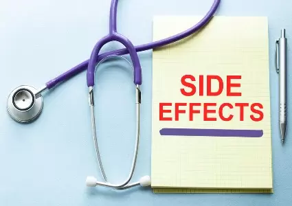 Side effect written in red on a yellow notepad next to medical equipment