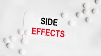 On a white vise sign SIDE EFFECTS, next to white tablets. The second word is highlighted in red