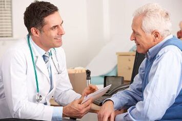 Older man who is patient talking to his doctor at his desk