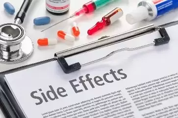 Picture of side effects on clip board surrounded by medical equipment
