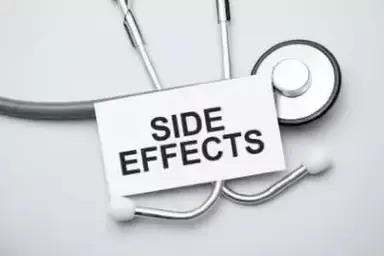 Paper with side effects on a table and grey stethoscope