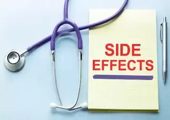 Side effects in red on a yellow notepad next to a stethoscope.