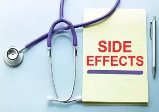 side effects written in red on a yellow notepad next to stethoscope