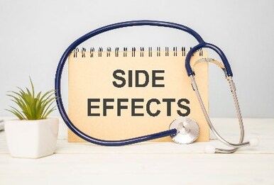 Side effects written on tan notepad next to plant and stethoscope