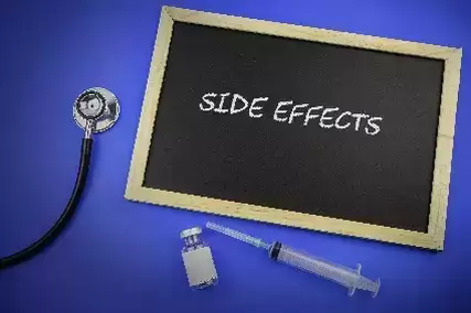Stethoscope, syringe, medication ampule and Chalk board with description side effects on blue background. Medical concept.