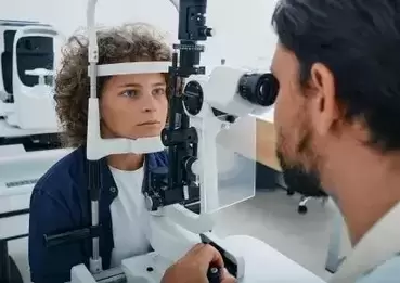 Young female getting eye exam from male doctor